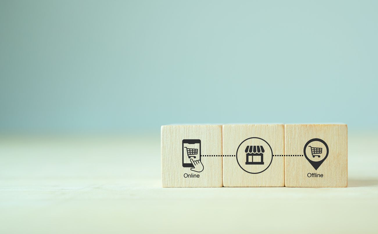 Wooden blocks with icons for online store and offline store connected by a brand store