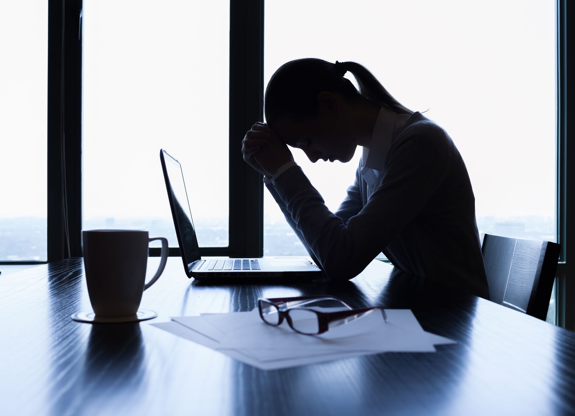 A female employee getting stressed out in front of a laptop