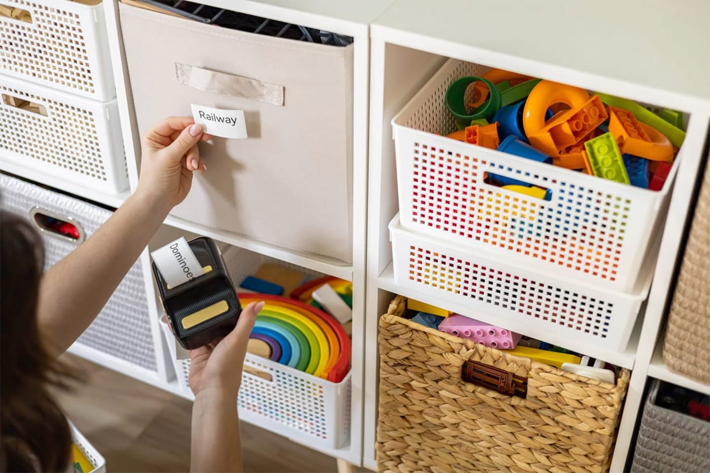 Woman mother applying paper sticker with name title on basket container clean out of childish toys comfortable storage. Female housewife organizing domestic space for kids use print mark tag.