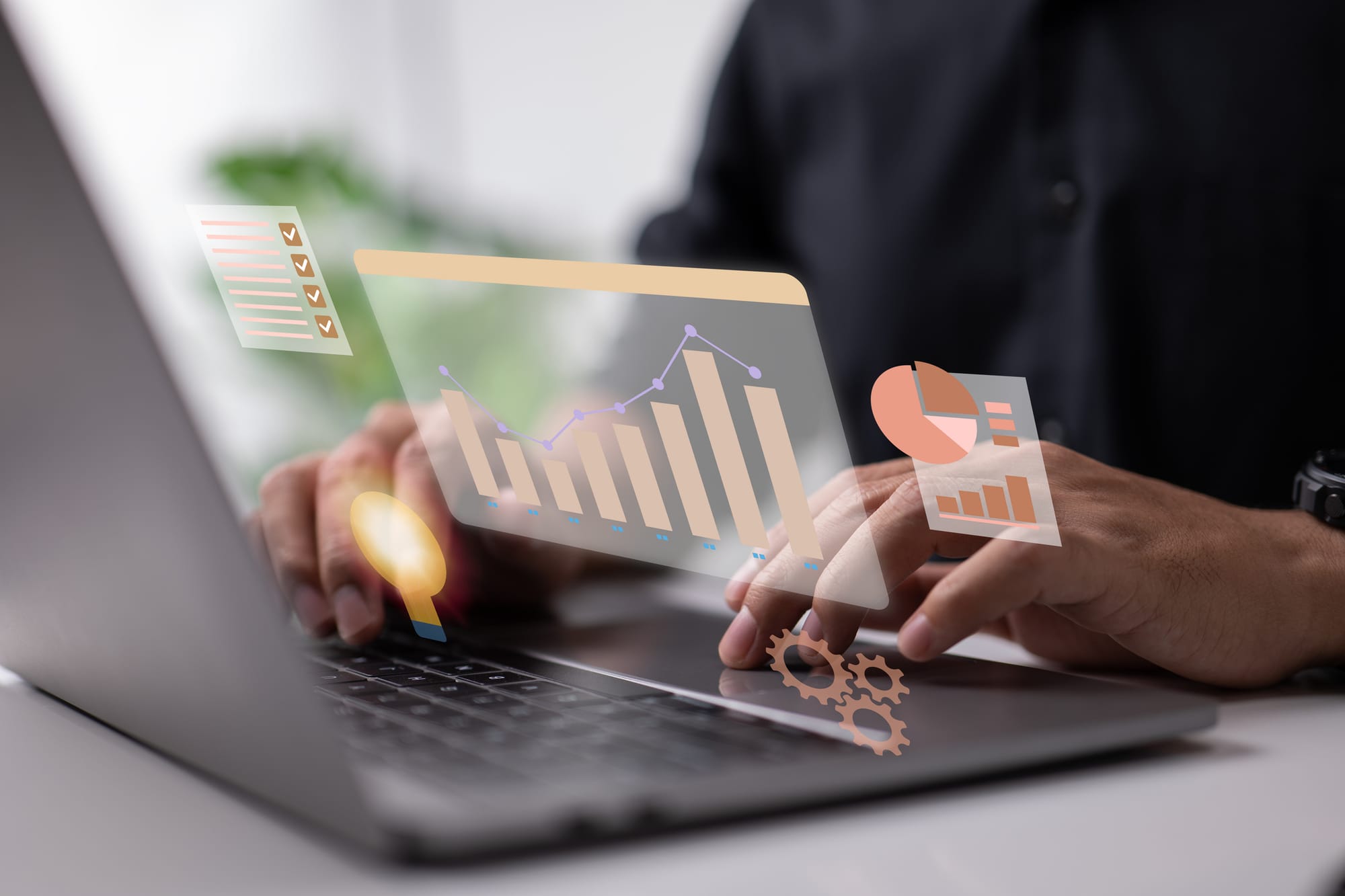 Person typing on laptop with visual dashboards and charts in the cloud.