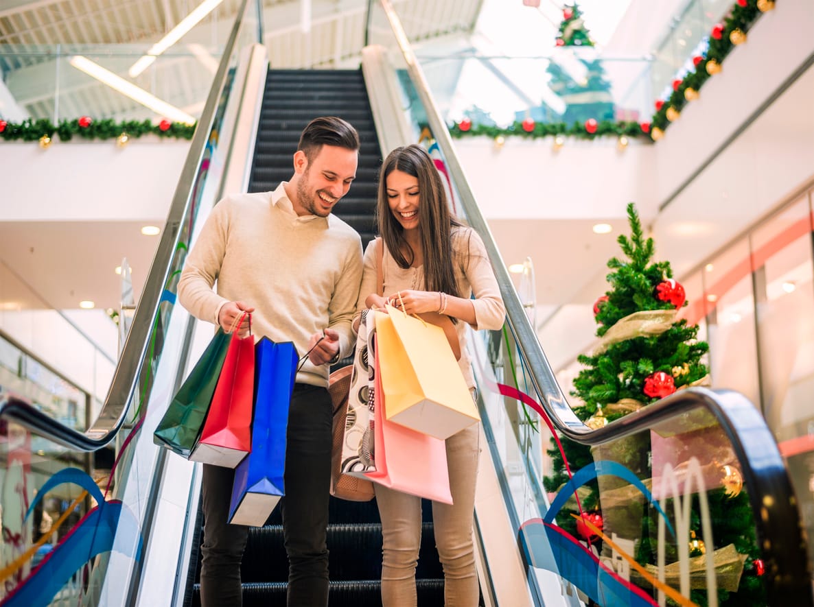 A happy young couple with Christmas shopping bags in a department store