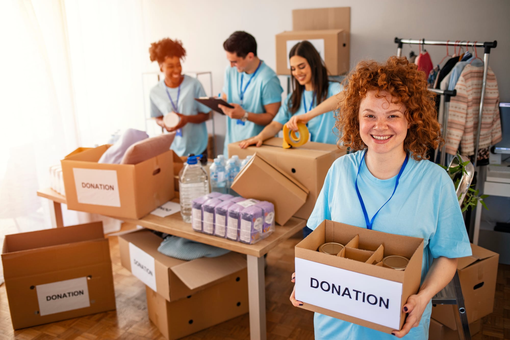 Volunteers sorting and packing donation boxes filled with essential items in charitable organization