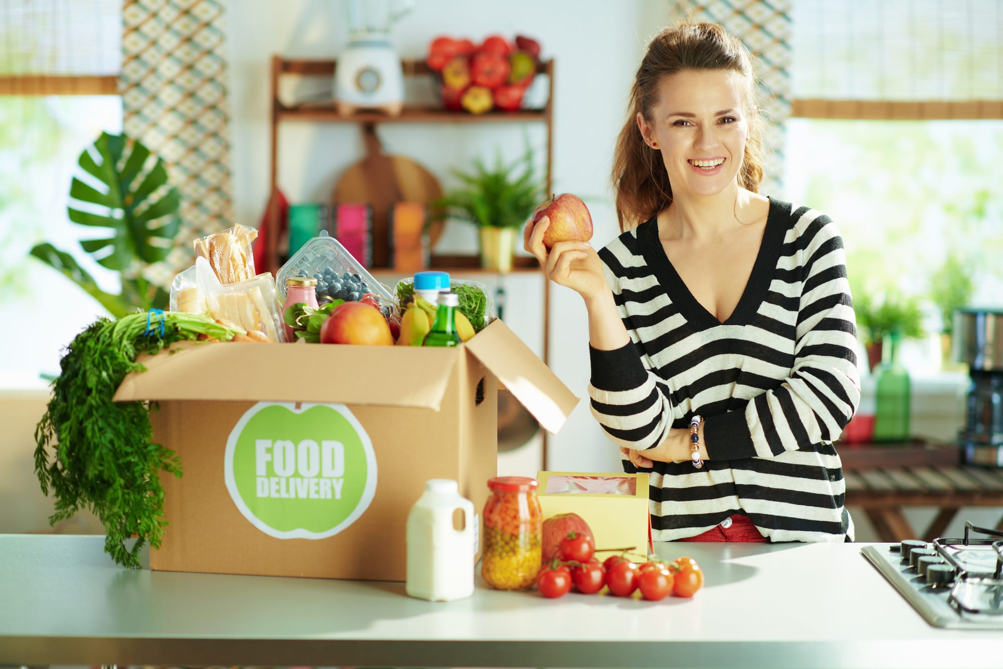 A customer receiving a curated box filled with fresh produce and food items based on her preferences.