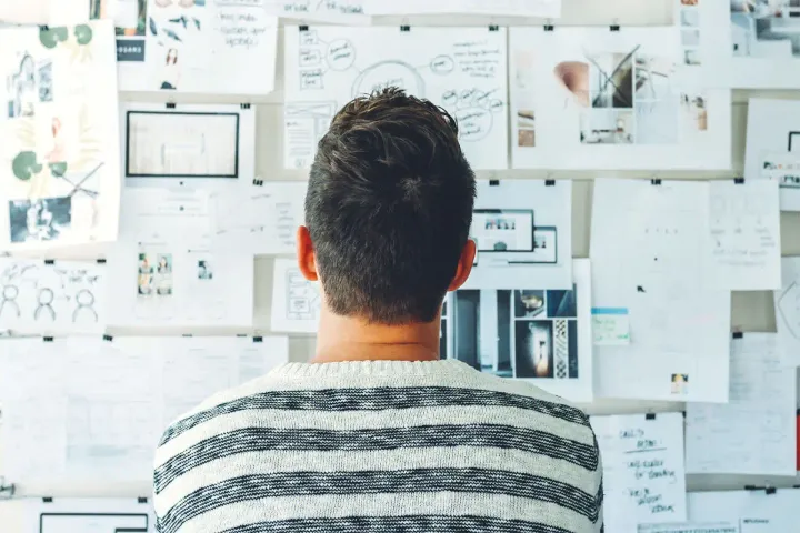 Man looking at a pin board with many designs