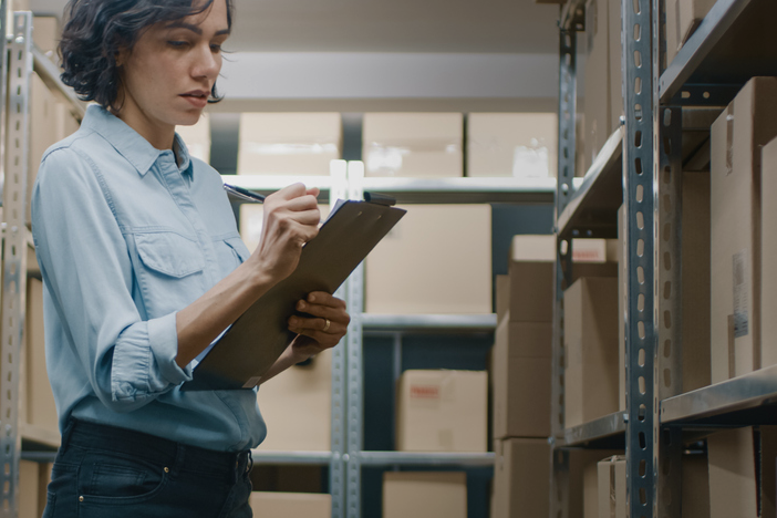 A female employee checking inventory in a warehouse