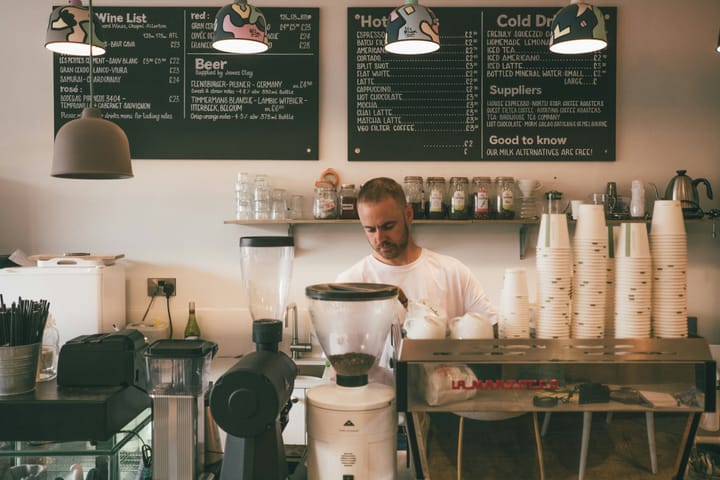 A barista working behind a coffee shop counter.