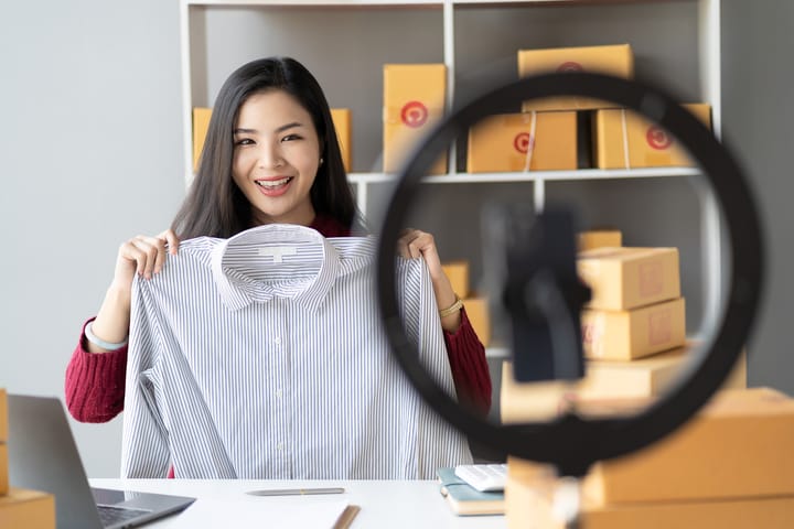 A business owner showcasing a shirt during a live selling event. 